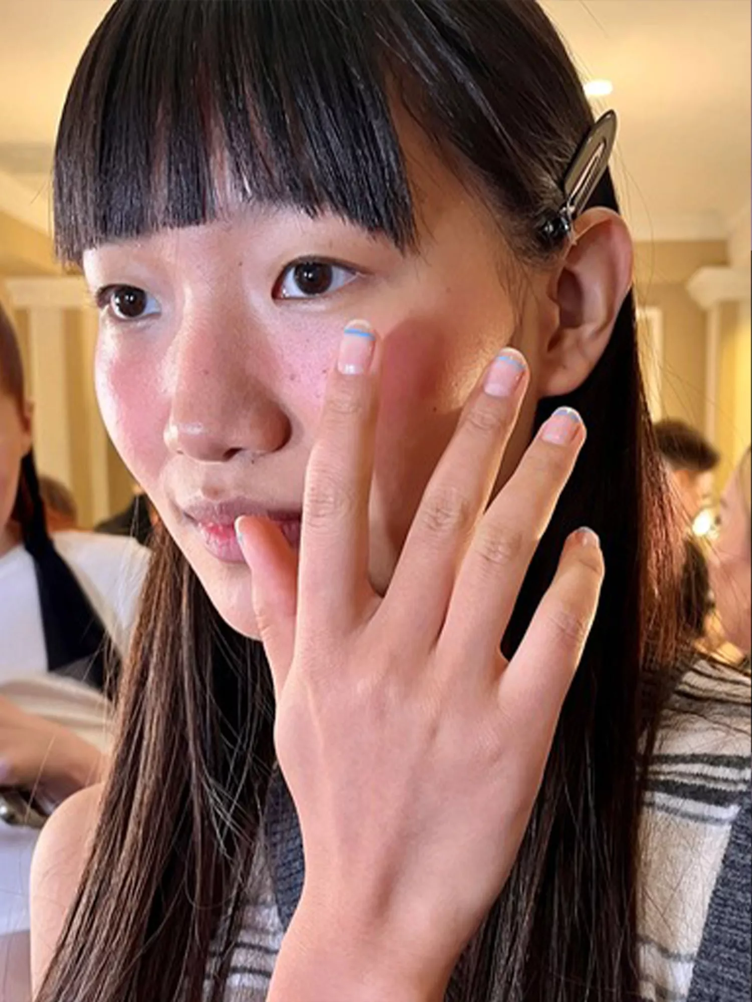 A woman wearing micro French tips, one of the Spring 2024 nail trends