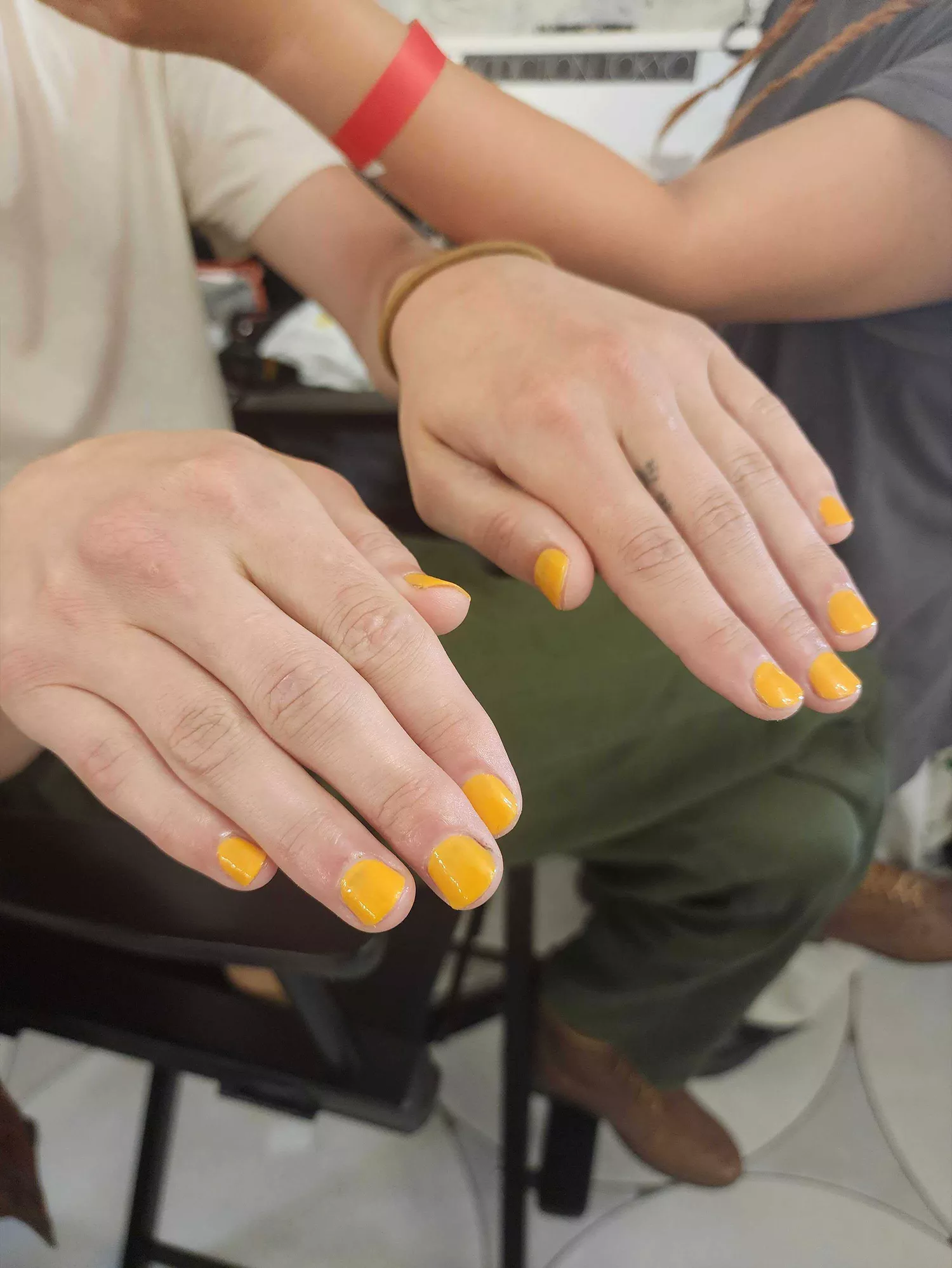 A model wearing orange ice nails, one of the Spring 2024 nail trends