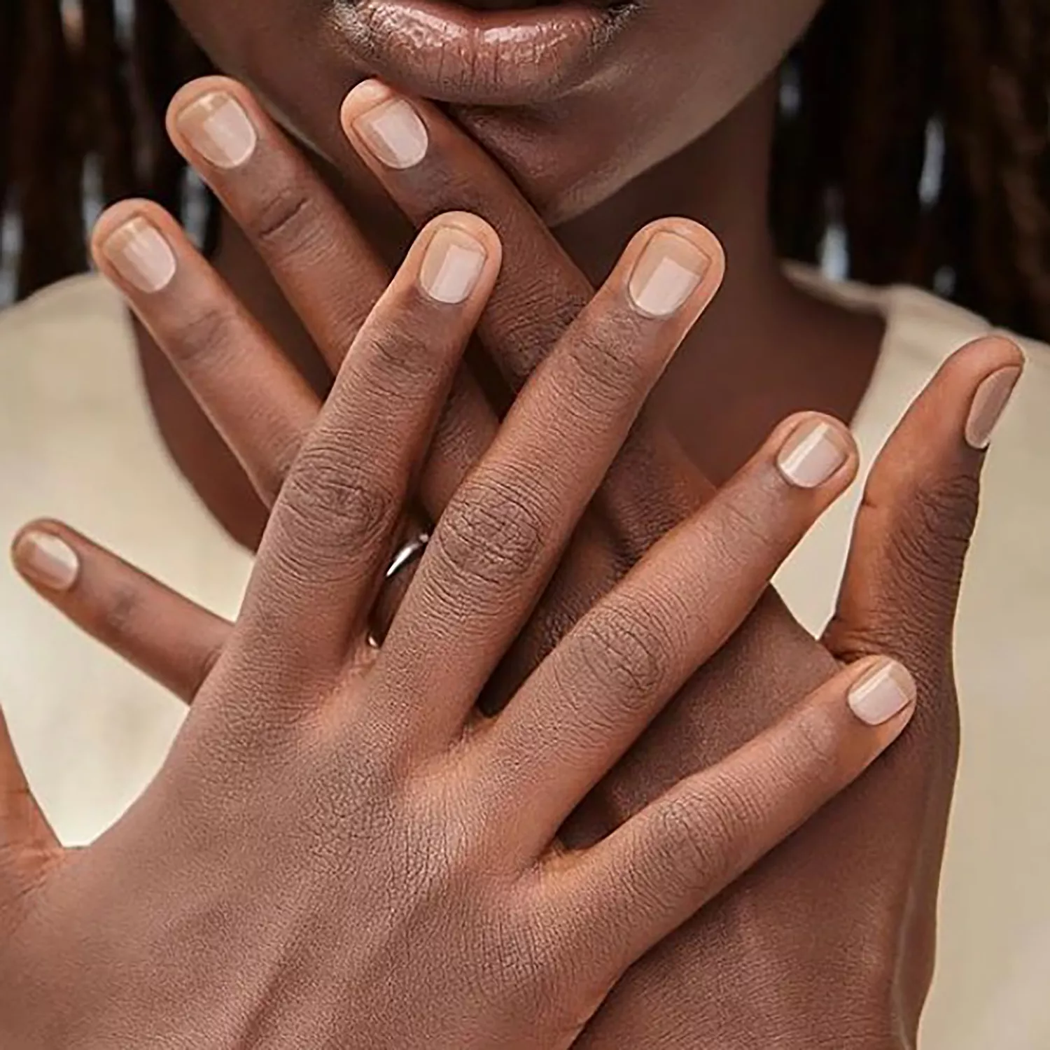 Close up of a neutral manicure with an abstract square detail