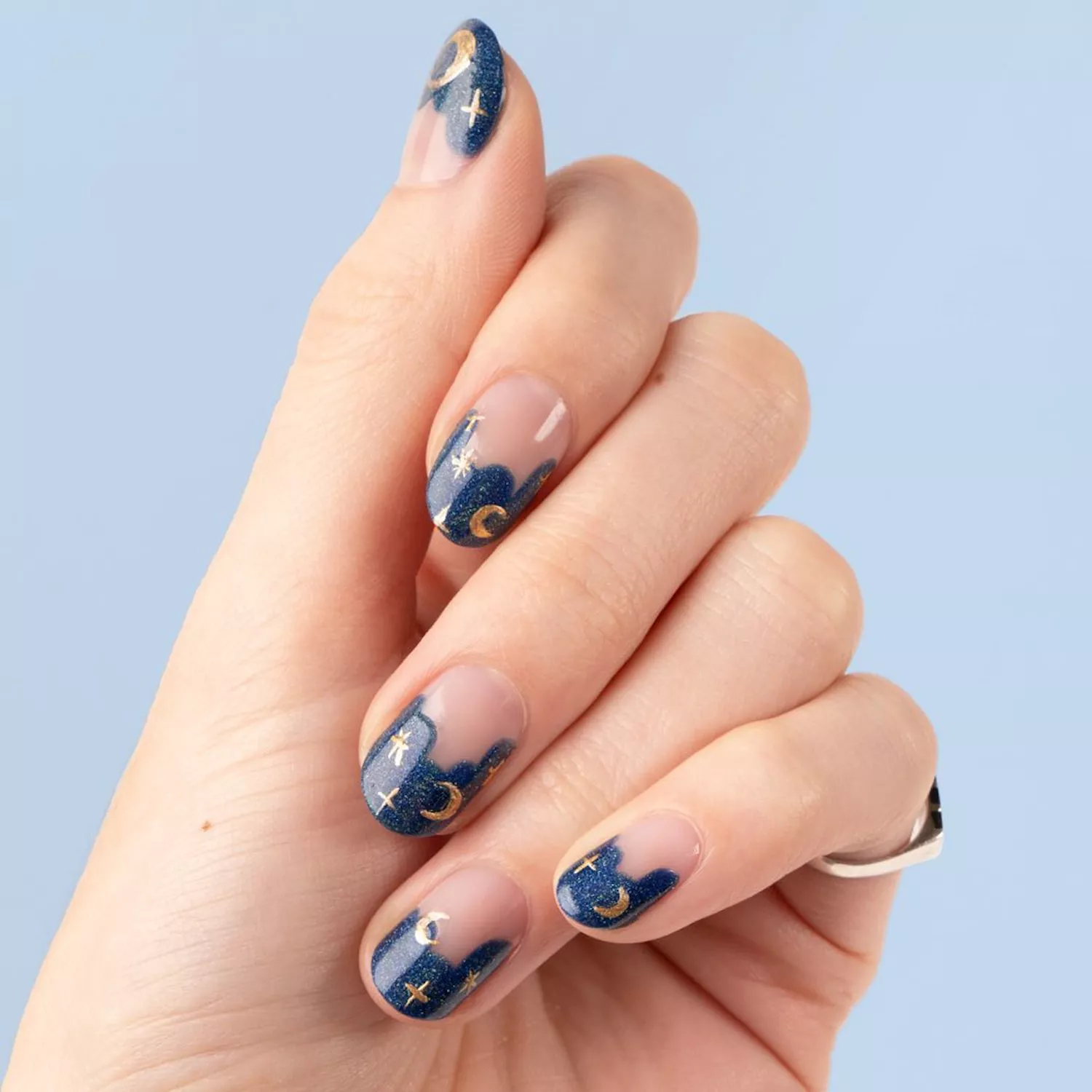 Manicure with shimmery blue tips and gold chrome star and moon designs