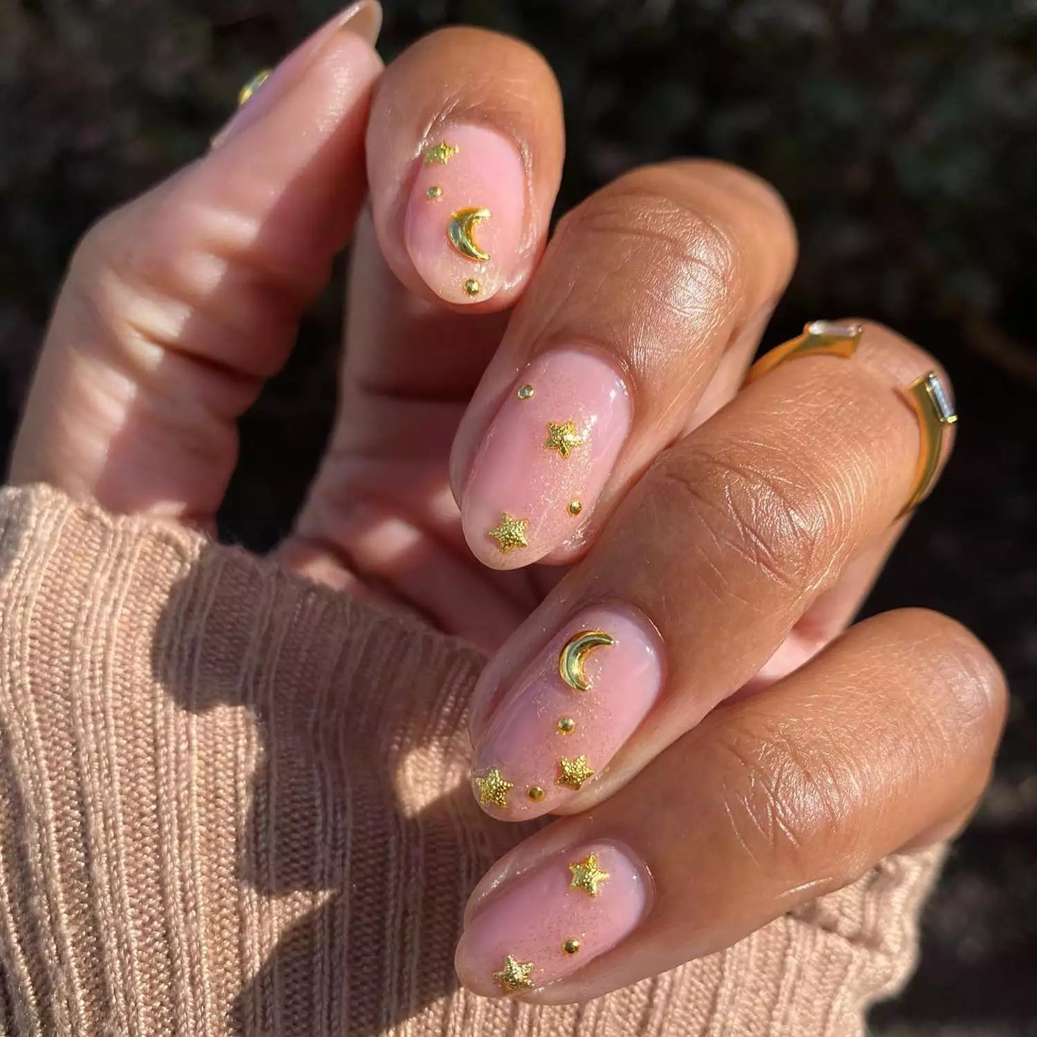 Sheer pink manicure with gold star and moon charms