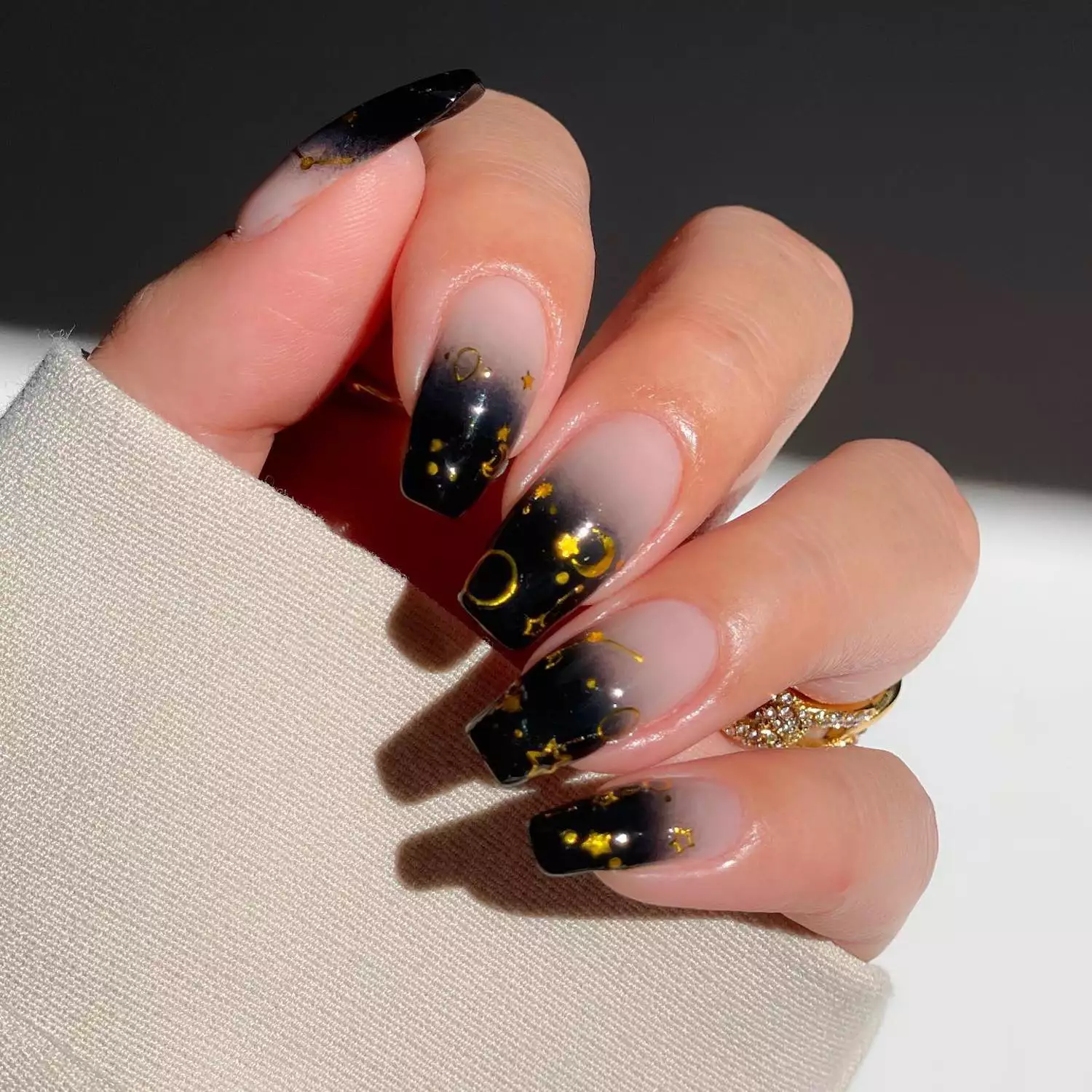 Long square-shaped black ombre manicure with gold star and moon decals