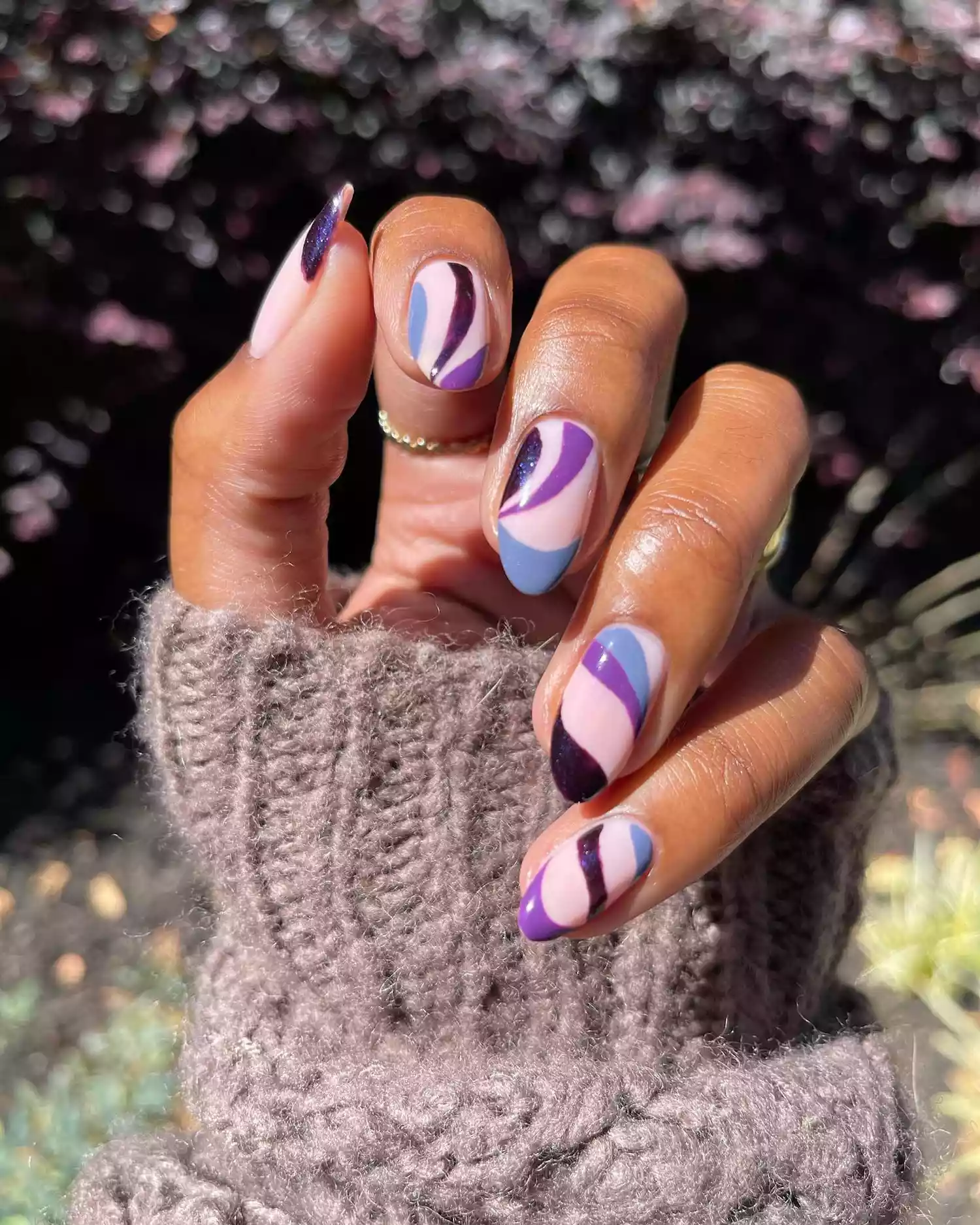 A swirly manicure featuring a various shades of purple