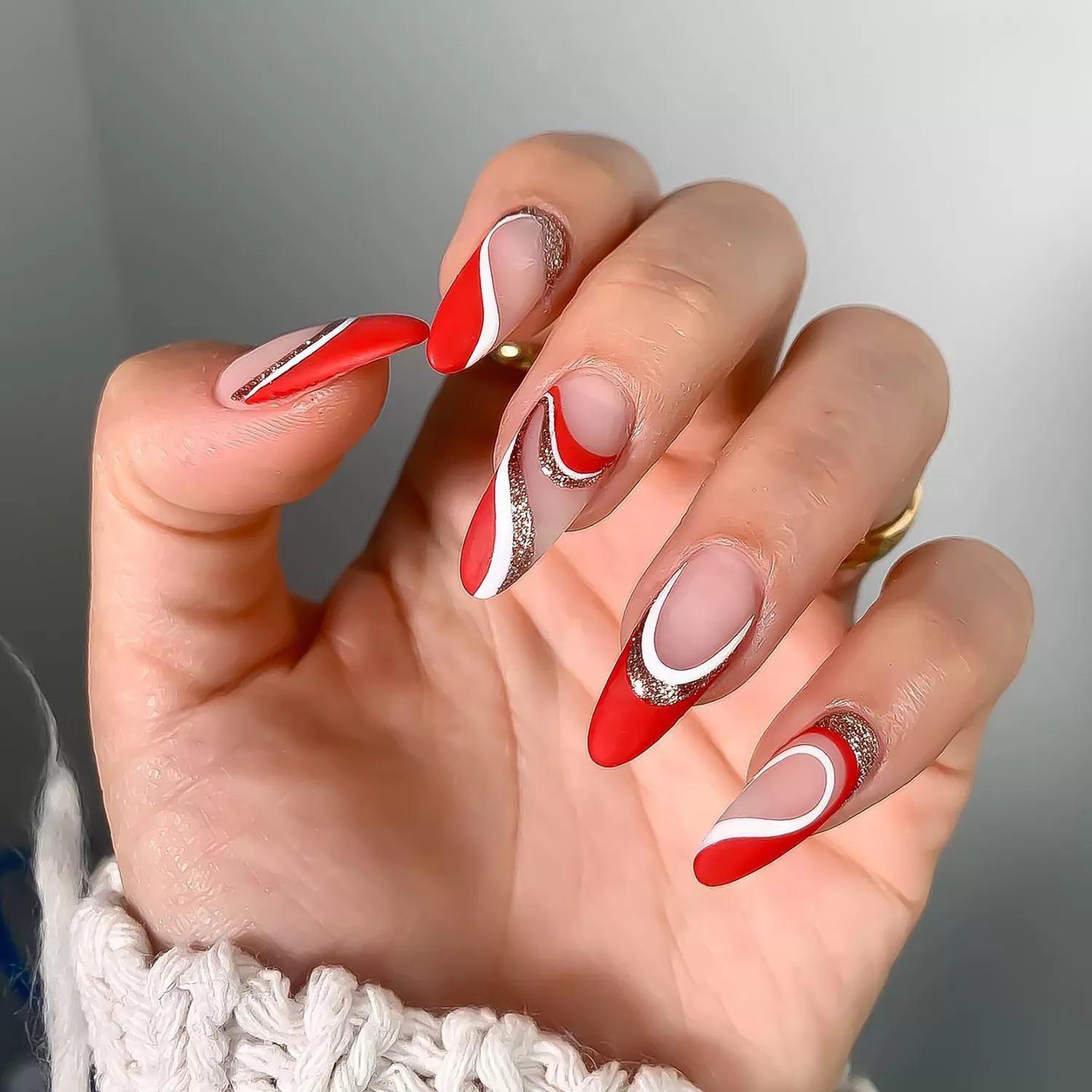 A red, white, and bronze glitter swirl manicure