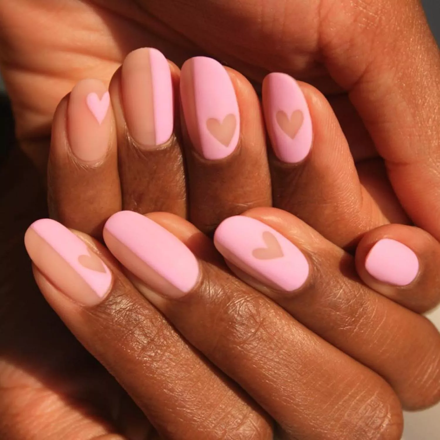 Manicure with half-nude, half-pastel pink base and negative space hearts