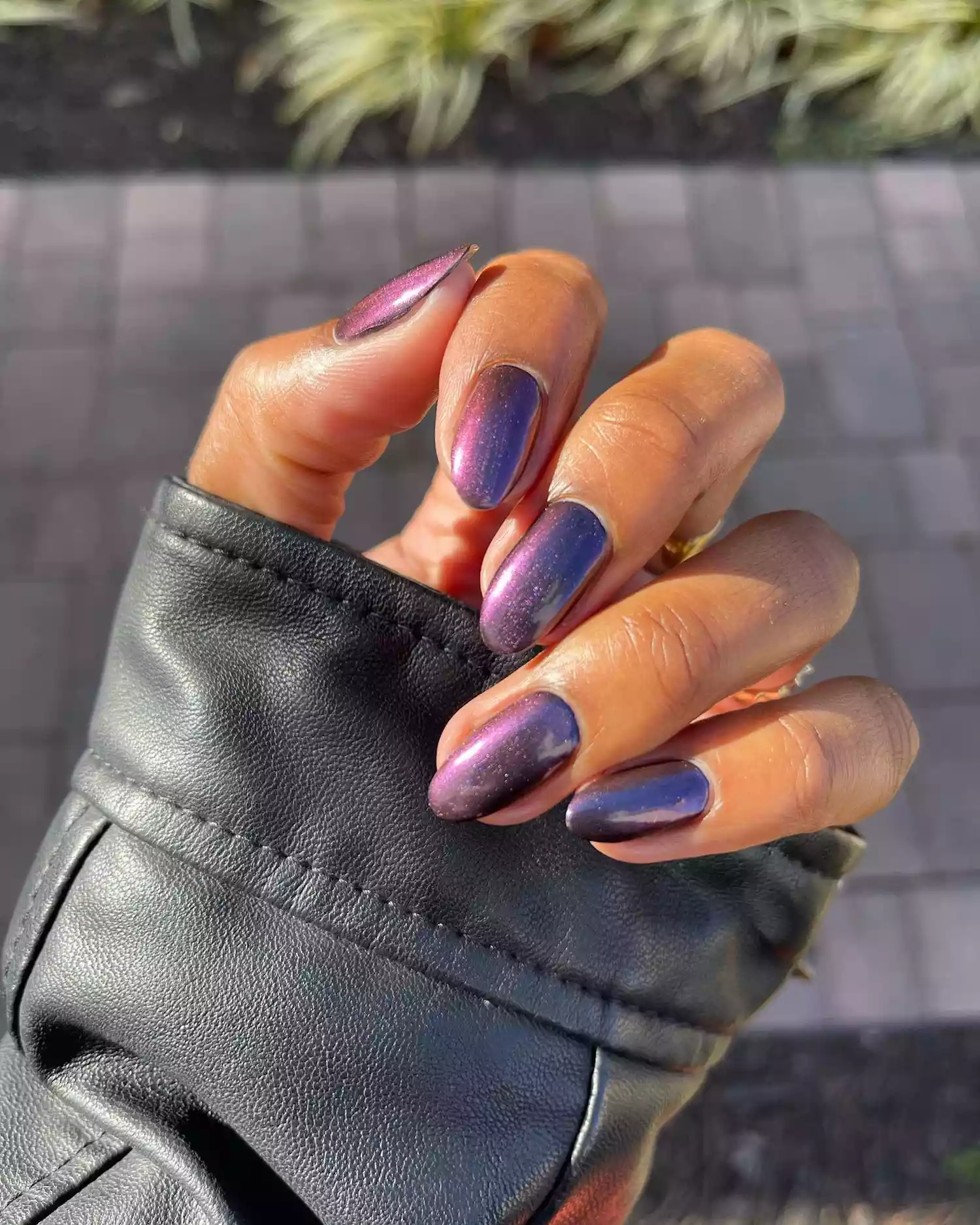 Close up of a shiny dark purple manicure