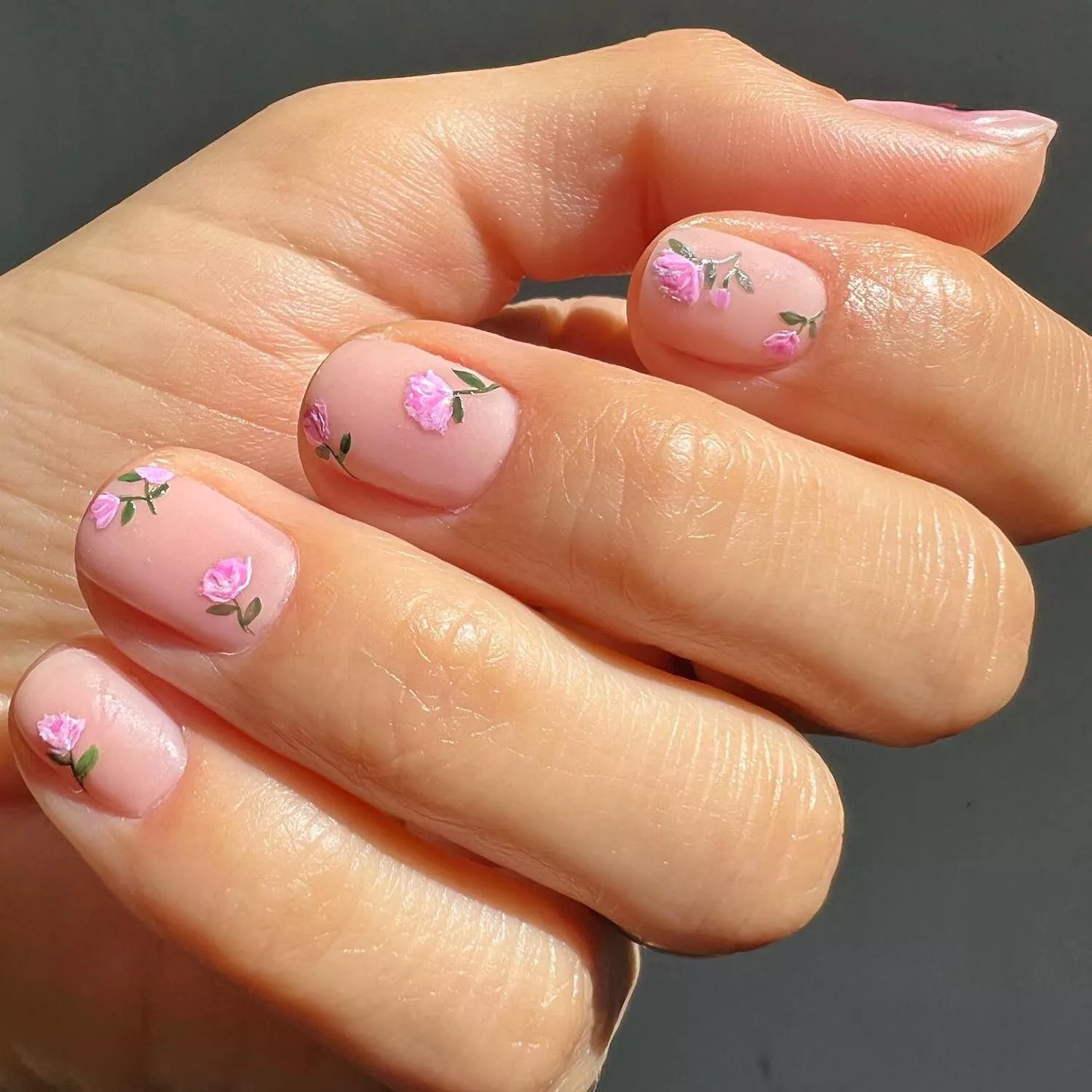 Manicure with nude base and pink hand-painted rose nail designs