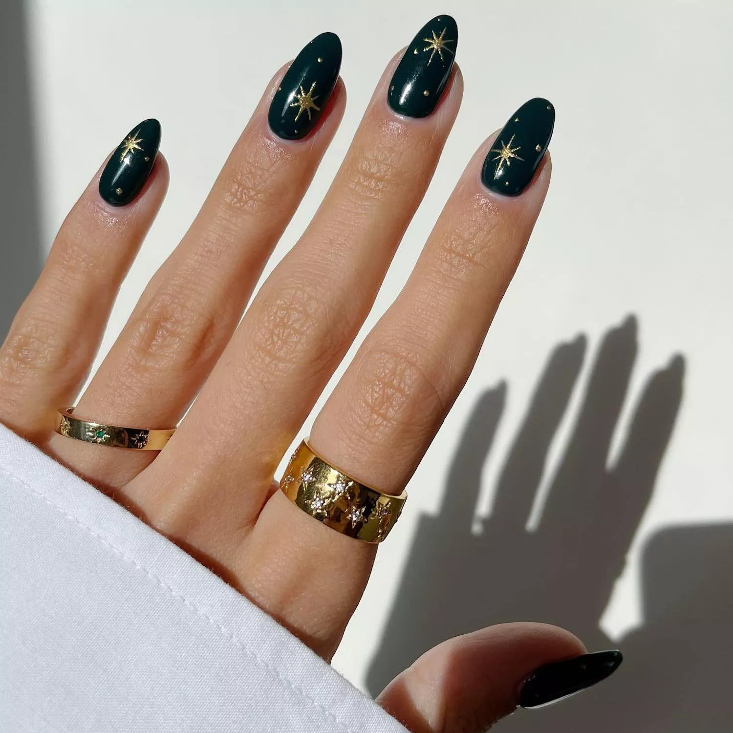 Deep green manicure with gold chrome star design