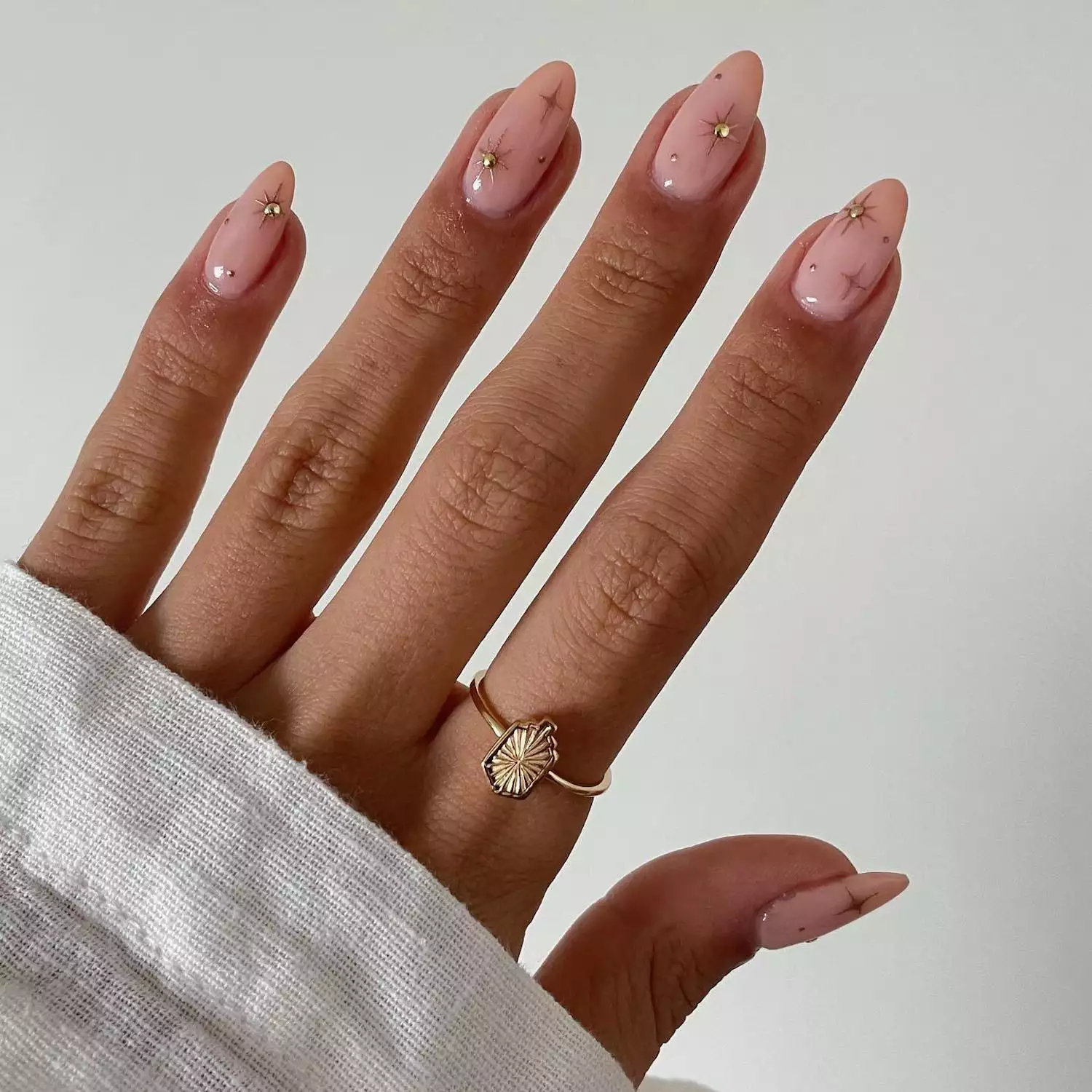 Pale pink manicure with chrome star nail designs