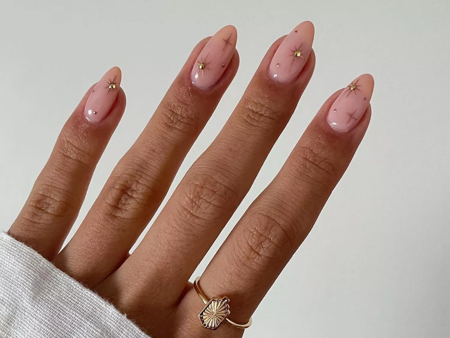 Pale pink manicure with chrome star nail designs