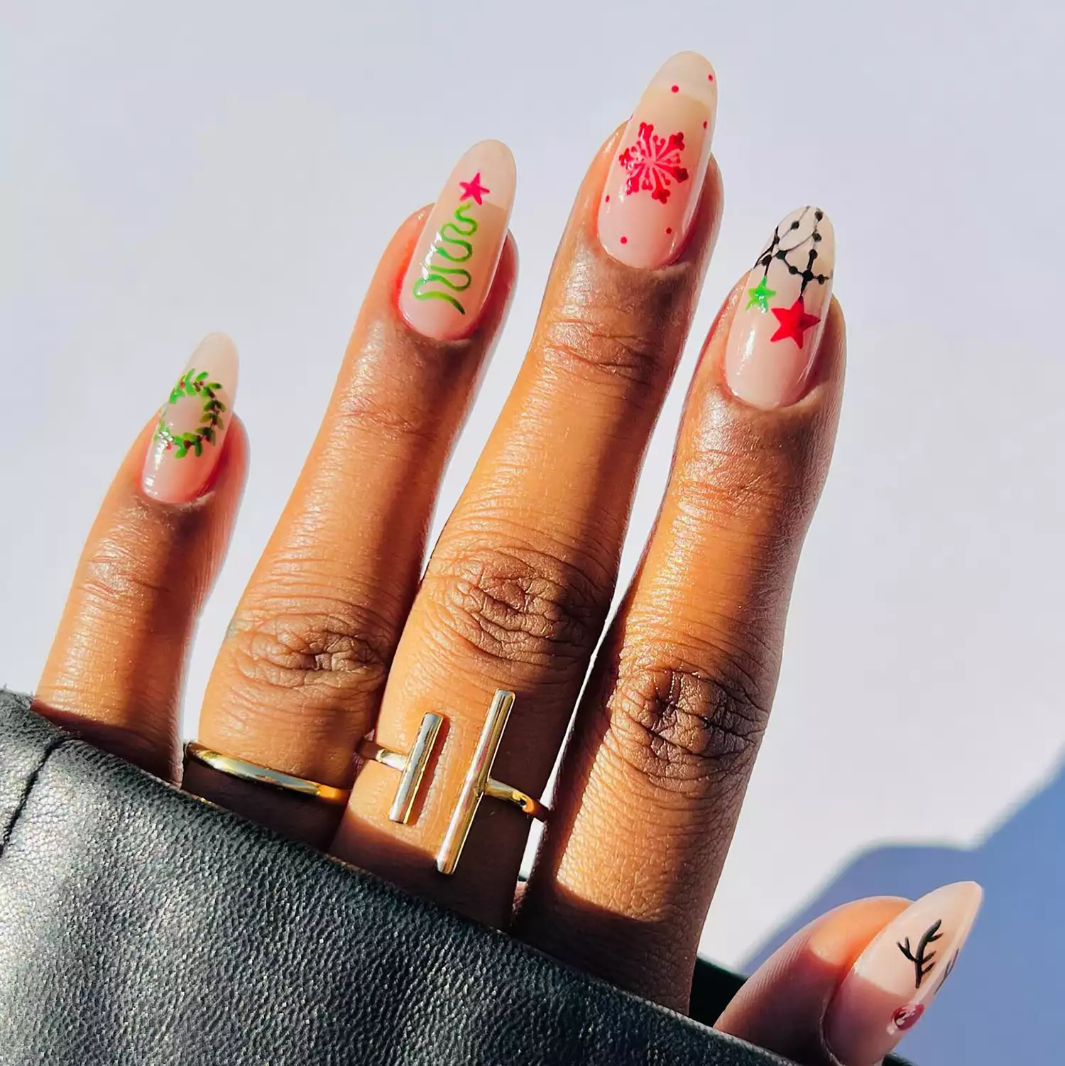 Close up of a holiday-themed mismatched manicure in shades of red and green