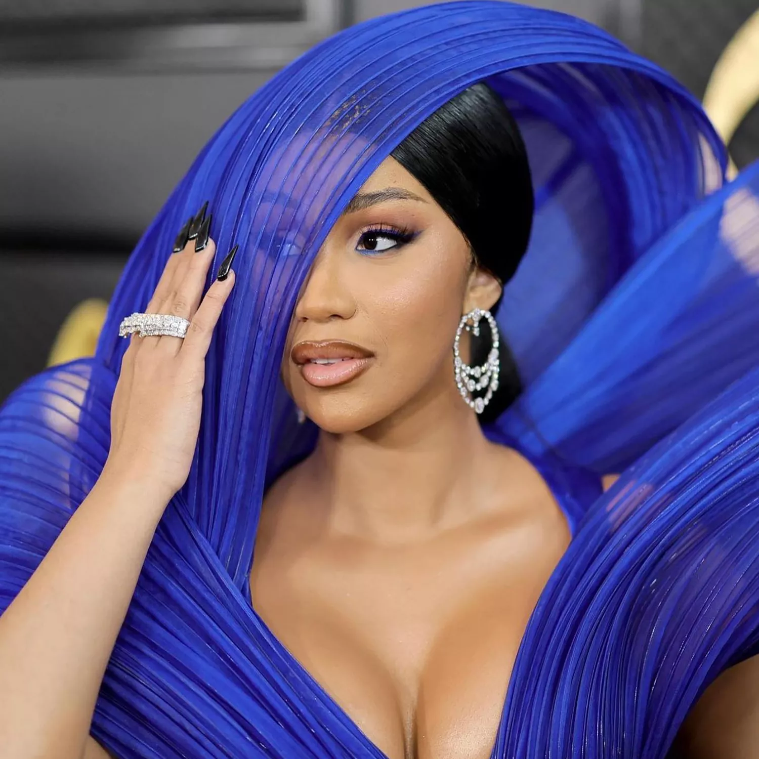 Close up of Cardi B's slick black nails against her blue architectural gown