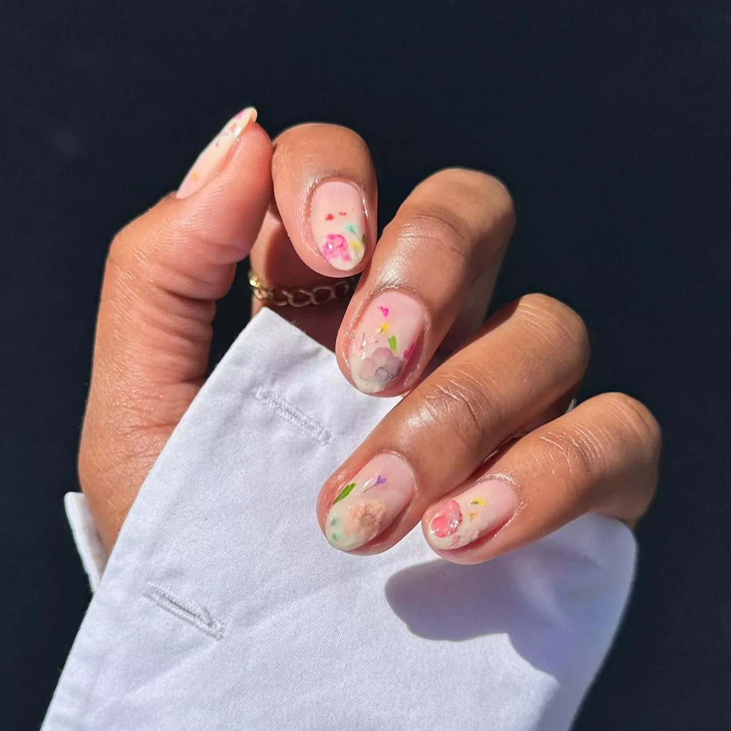 Milk bath manicure with neutral base and colorful pressed flower accents