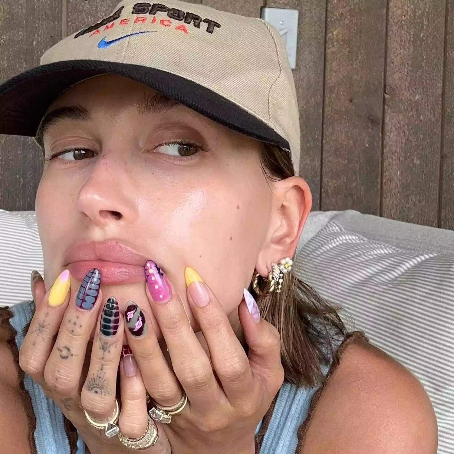 Hailey Bieber poses with a mismatched manicure featuring snakeskin and tie dye designs