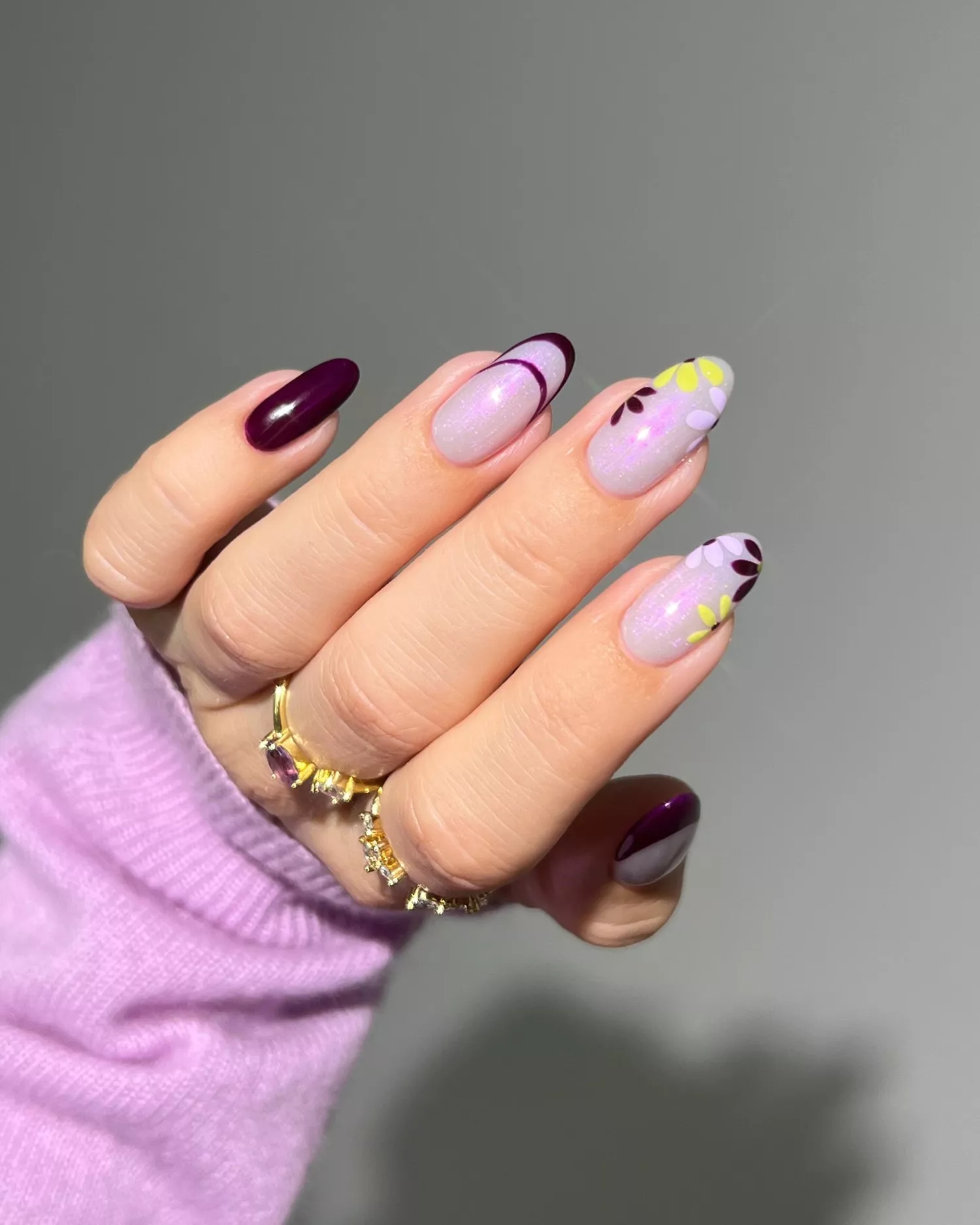 Close up of a purple manicure with floral details 