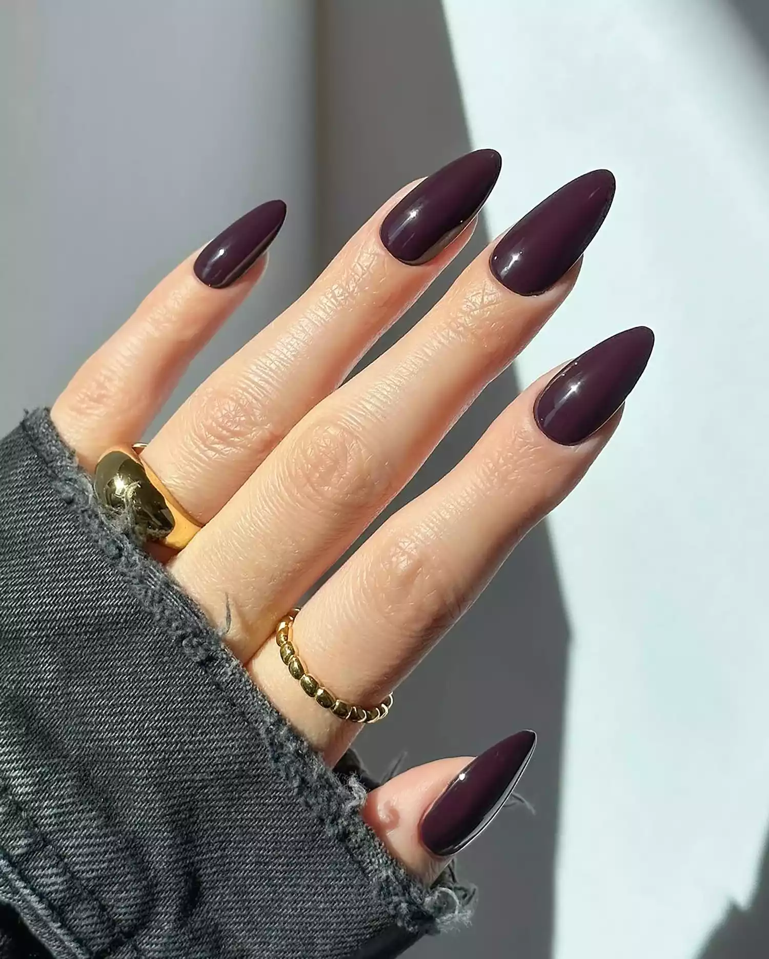 A close up of a deep eggplant purple mani in an almond shape