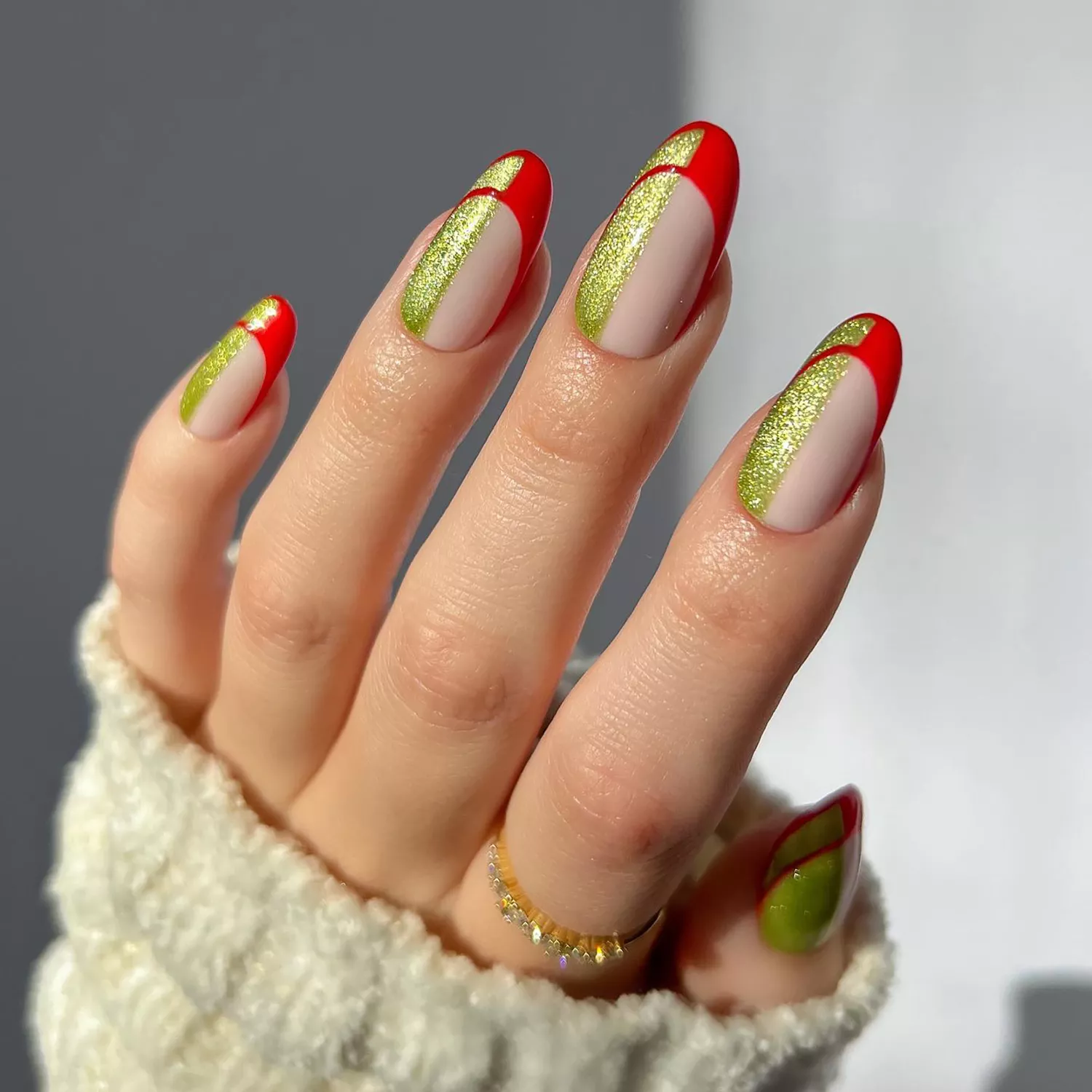 Close up of a half gold-green, half red abstract manicure