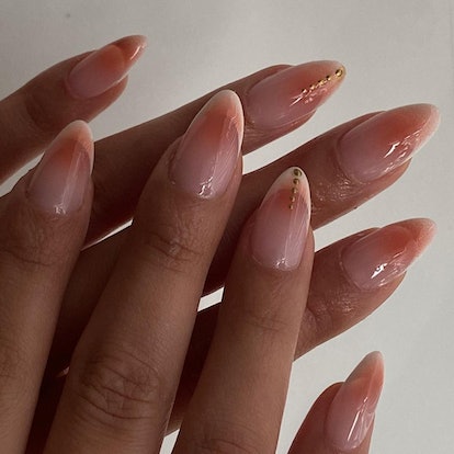 Light orange aura nails are on-trend for a 2024 "peach fuzz" manicure.