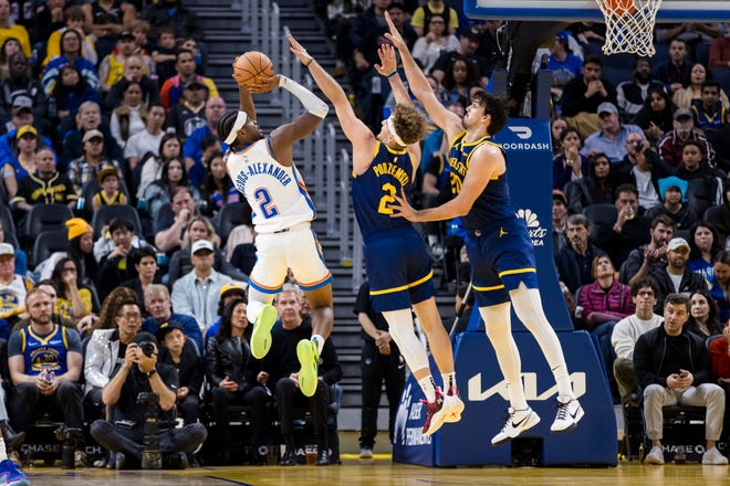 Nov. 18: Golden State Warriors guard Brandin Podziemski and center Dario Saric defend Oklahoma City Thunder guard Shai Gilgeous-Alexander during the second half at Chase Center.