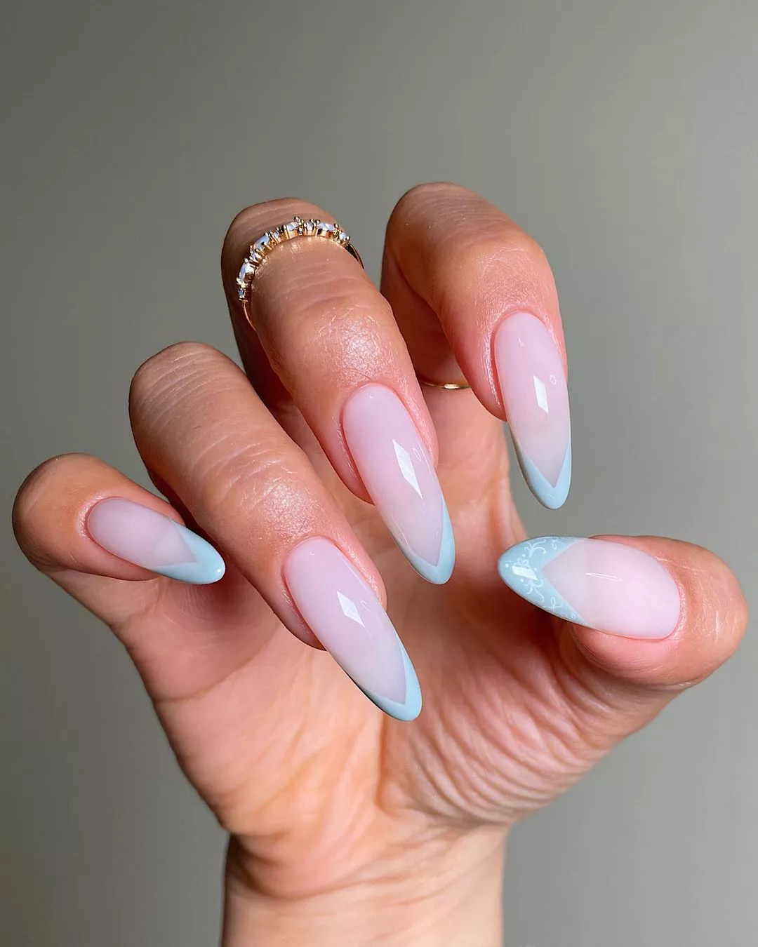 A woman wearing a simple nail design featuring blue tips