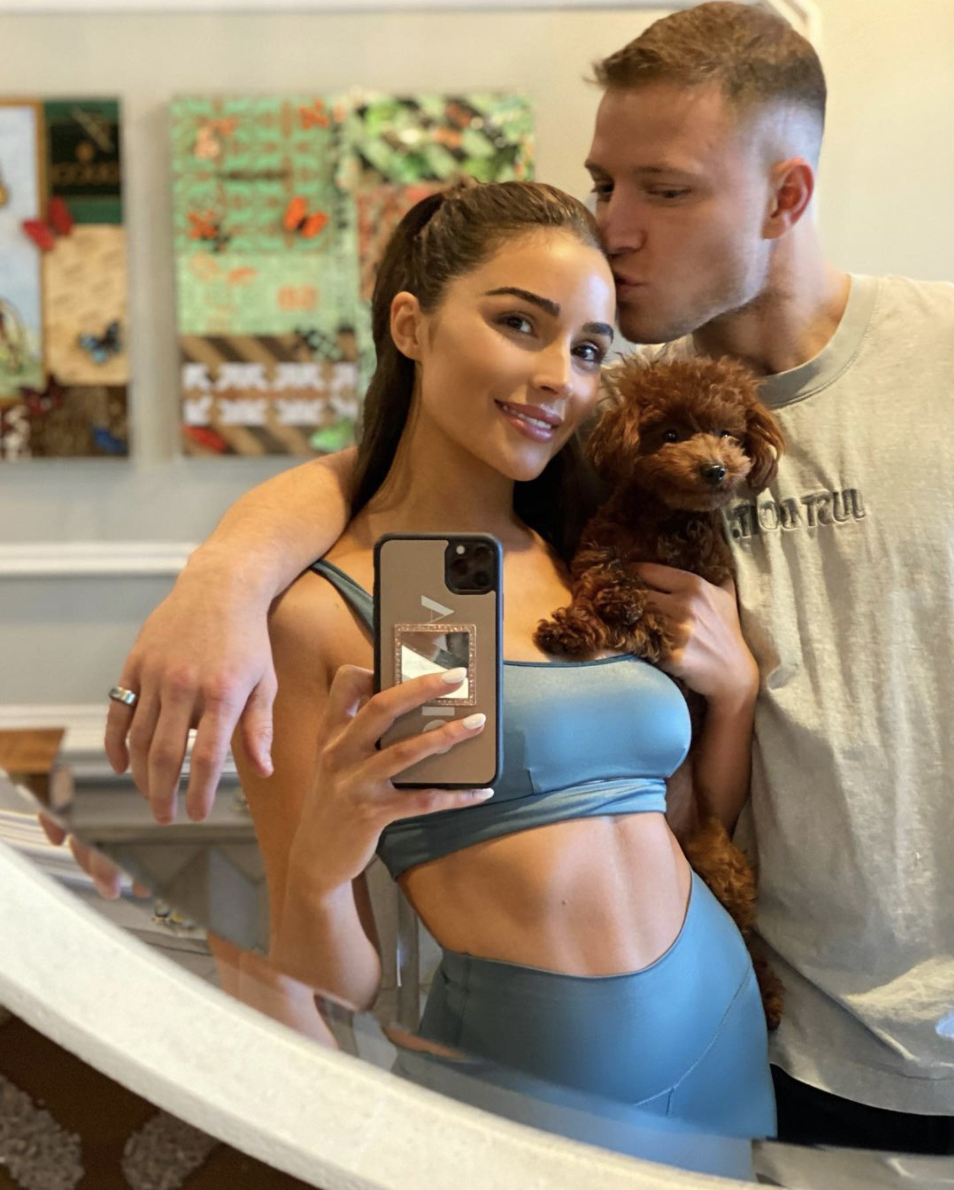 Olivia Culpo shared a sweet photo with her puppy Oliver Sprinkles and boyfriend Christian McCaffrey on Saturday, Jan. 23, 2021.