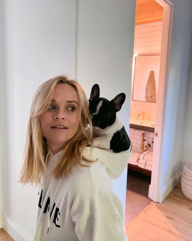 Reese Witherspoon takes her role as a fur parent very seriously: the actress shared a silly photo of herself chauffeuring her dog Minnie around in her hood on Nov. 20, 2020 with the caption