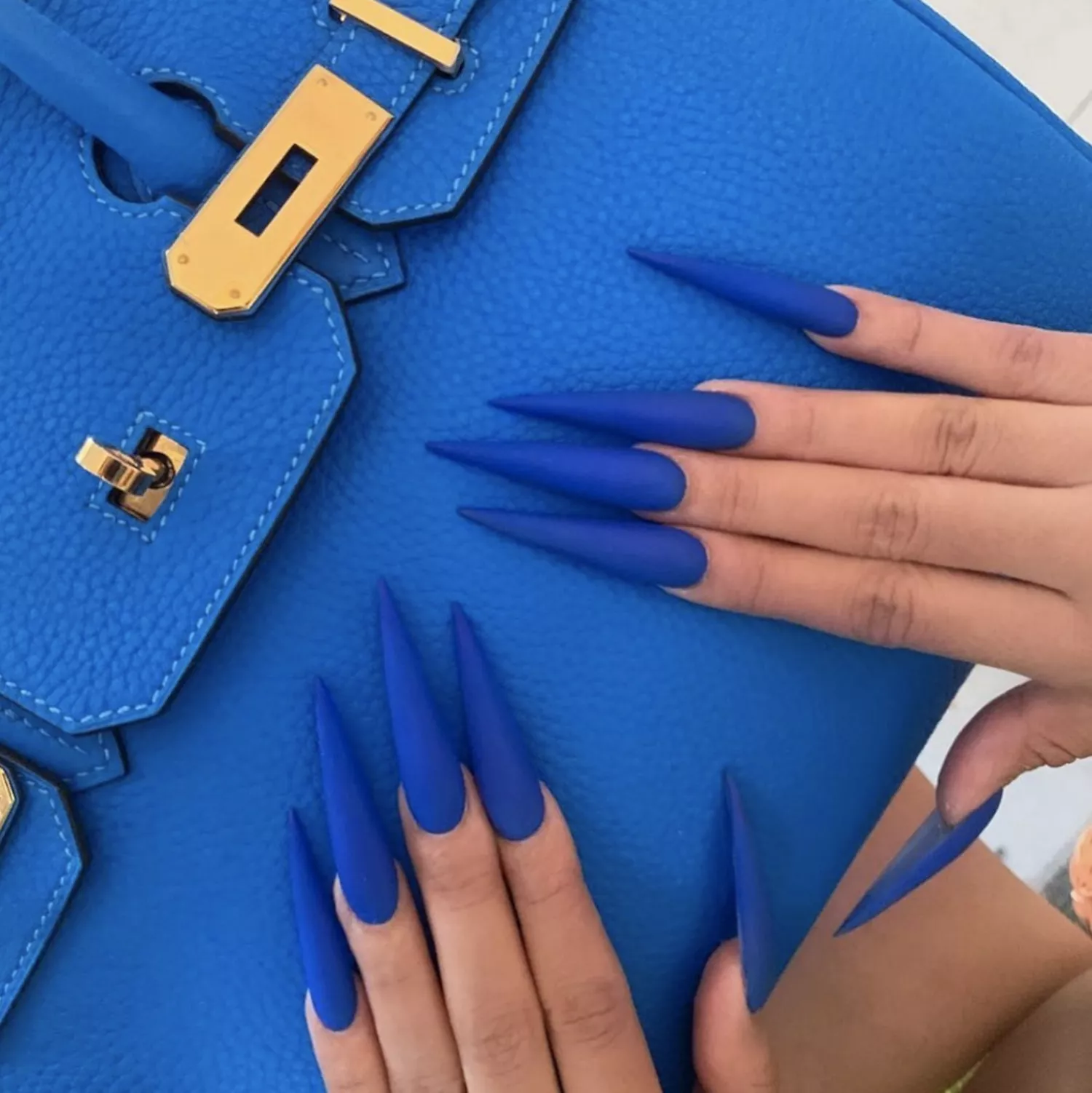 A cobalt blue manicure against a blue Hermes bag