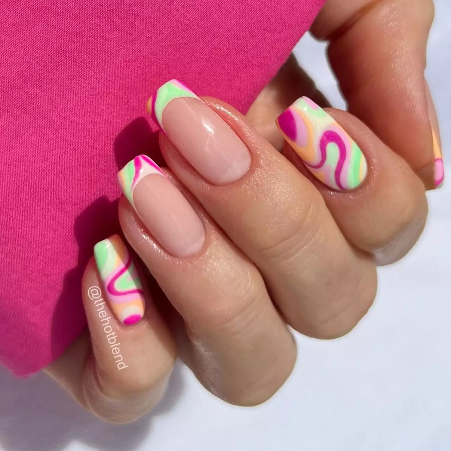 French Swirl Accent nails in shades of hot pink, green, and orange