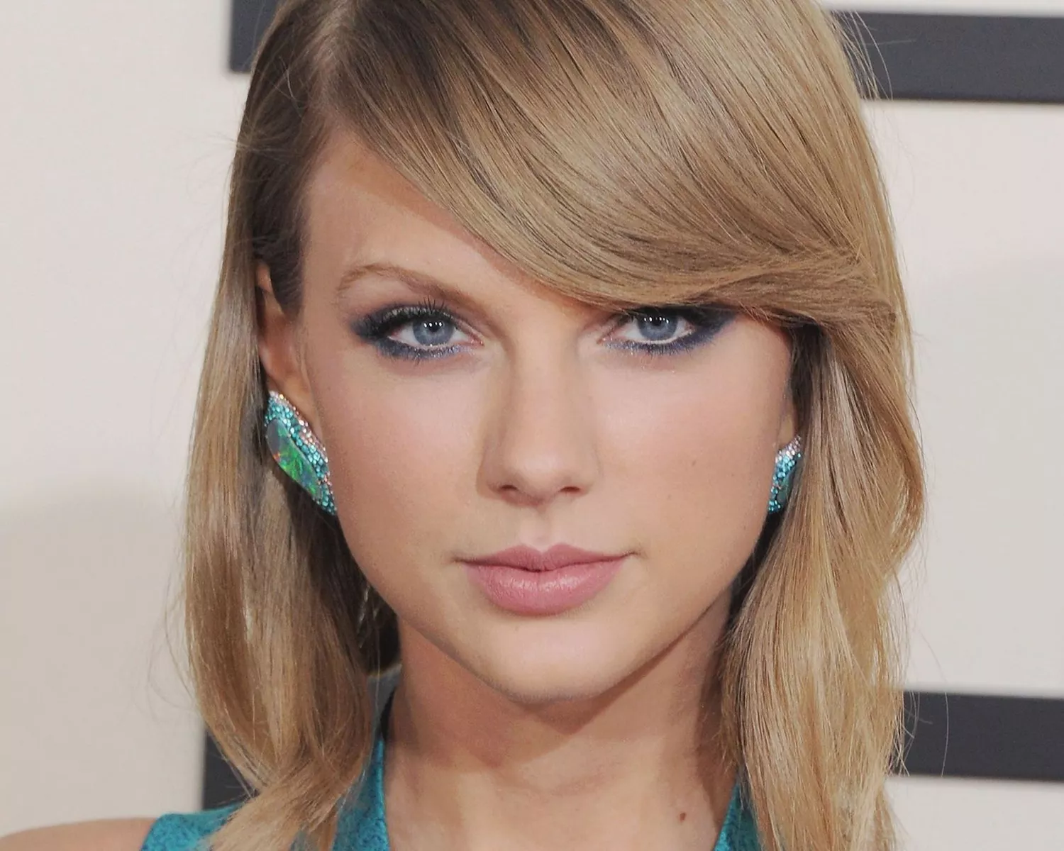 Taylor Swift wears a lightly tousled long bob hairstyle with side-swept bangs