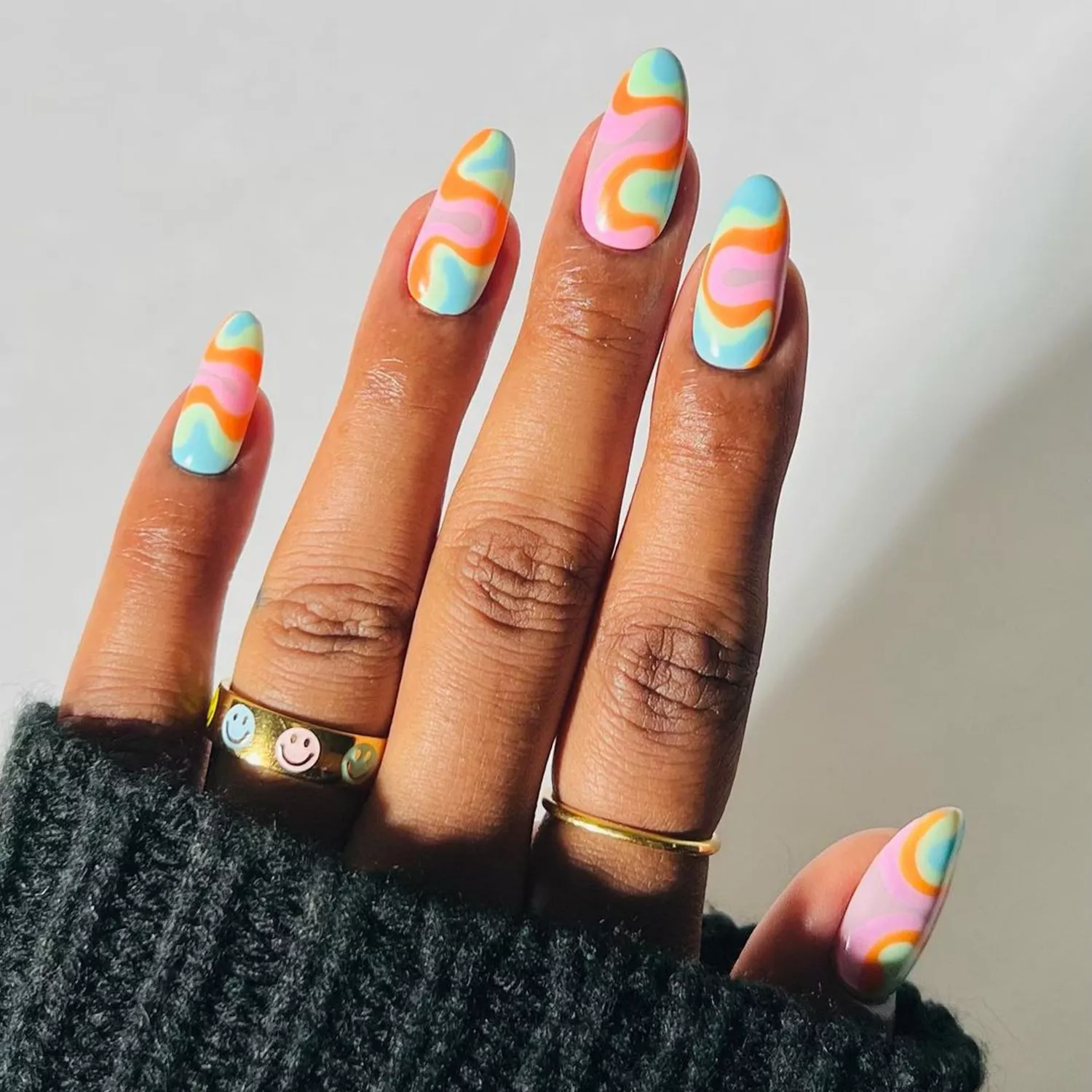 Groovy Pastel Swirl nails in shades of orange, blue, and green