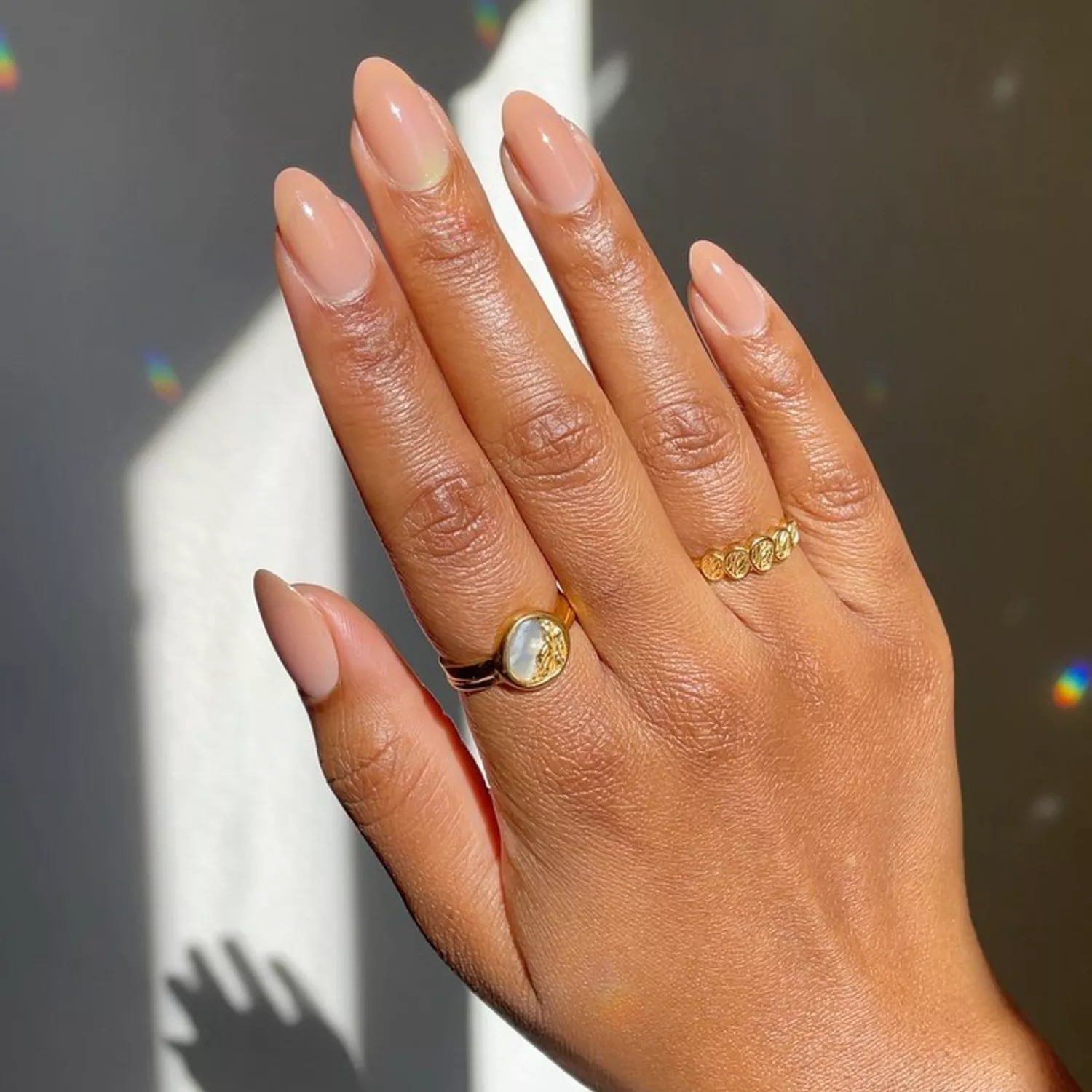 A hand with a sheery, glossy manicure 