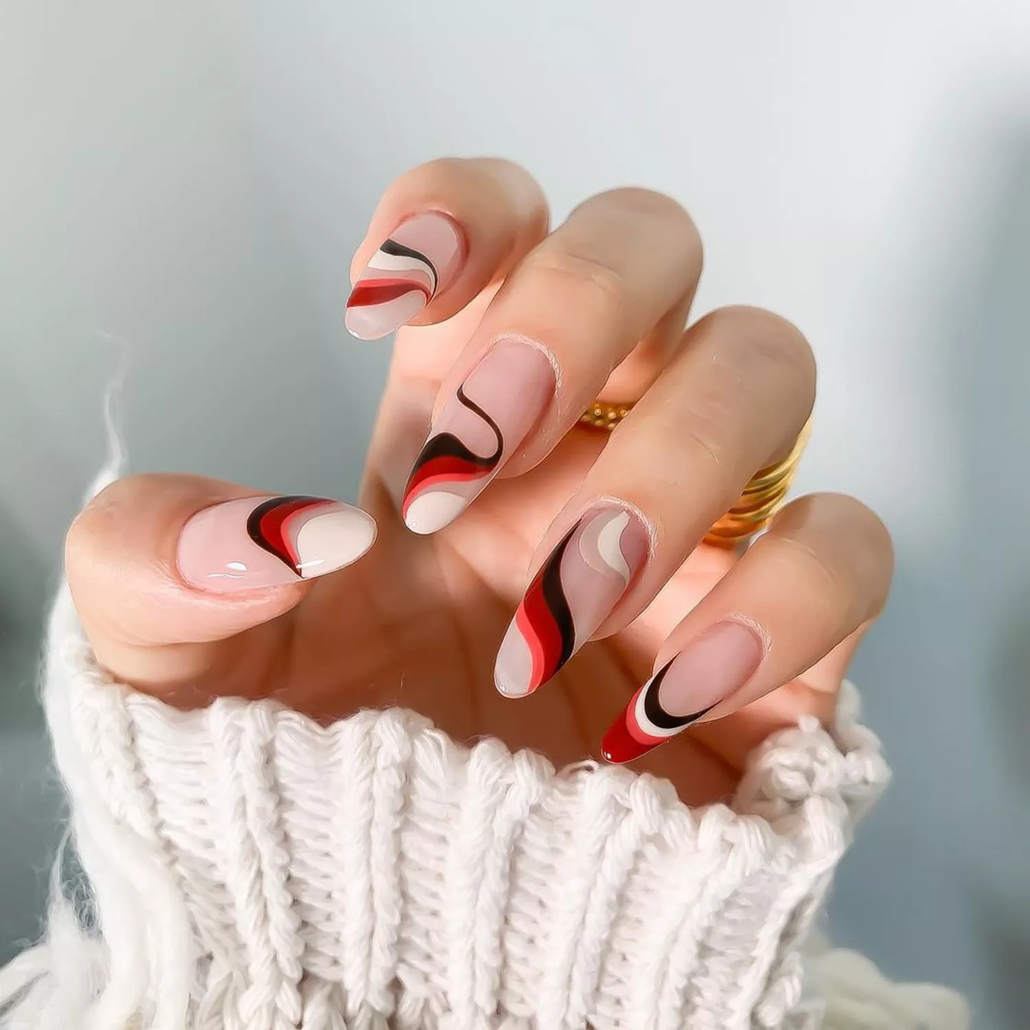 Red gradient swirl nails in shades of red against a white background