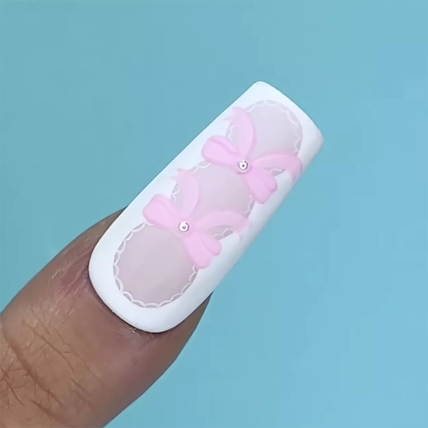 Close up of a nail with 2D pink bow accents