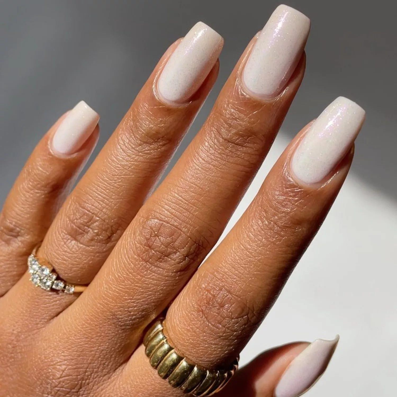 Close up of fingernails with a shimmery white square manicure