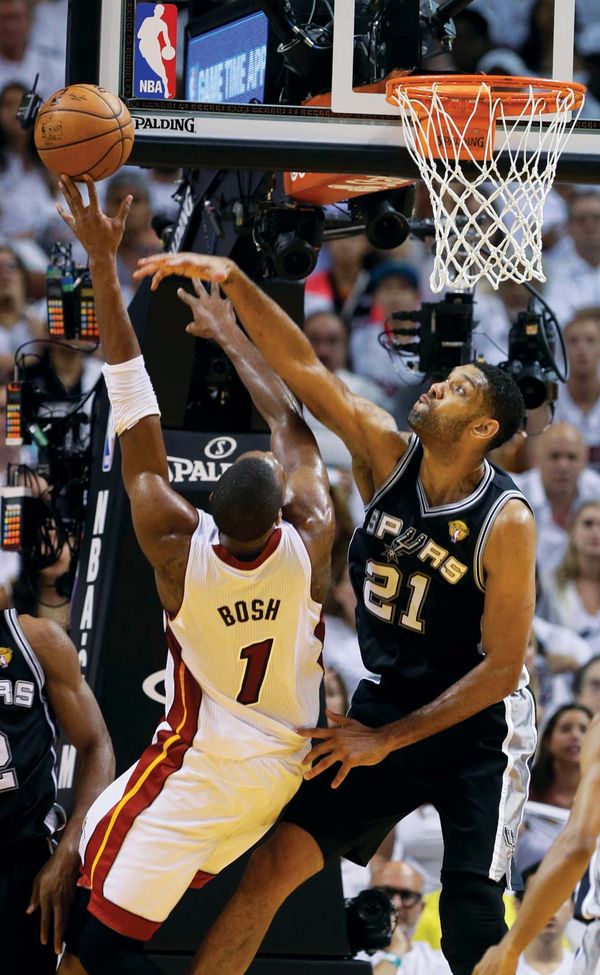 San Antonio Spurs forward Tim Duncan blocks a shot to the basket by Miami Heat center Chris Bosh during the first half of Game 4 of the NBA Finals in Miami on June 12, 2014.