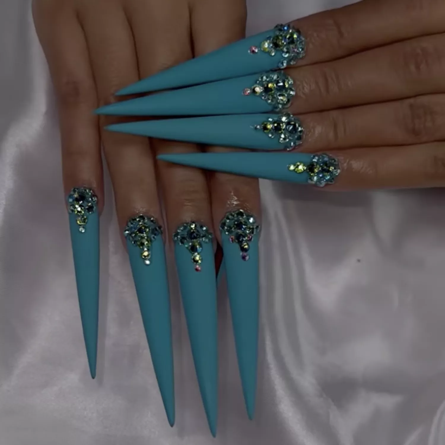 Close up of a bejeweled turquoise manicure