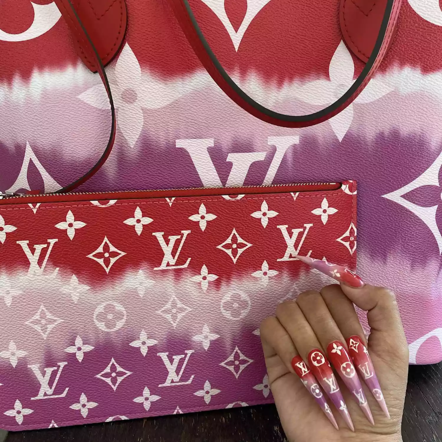 Close up of Cardi B with a Louis Vuitton manicure against her Louis Vuitton bag