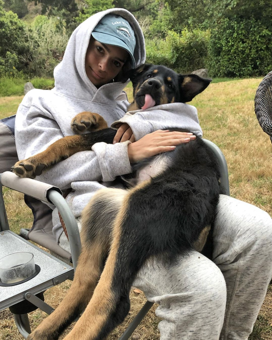 Model Emily Ratajkowski shares a sweet snuggle with her puppy Colombo, despite his bigger weight.