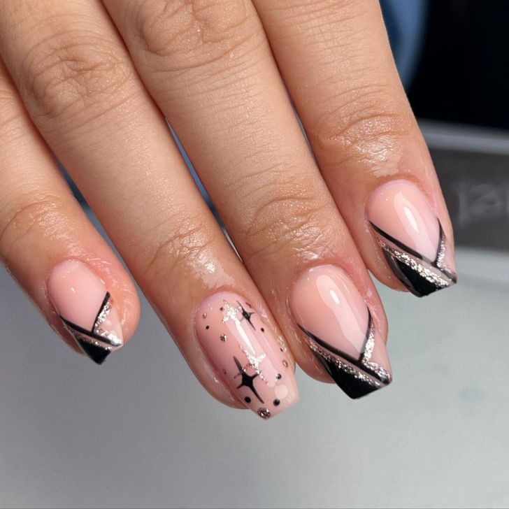 black and gold new years nails with geometric french tips and celestial designs