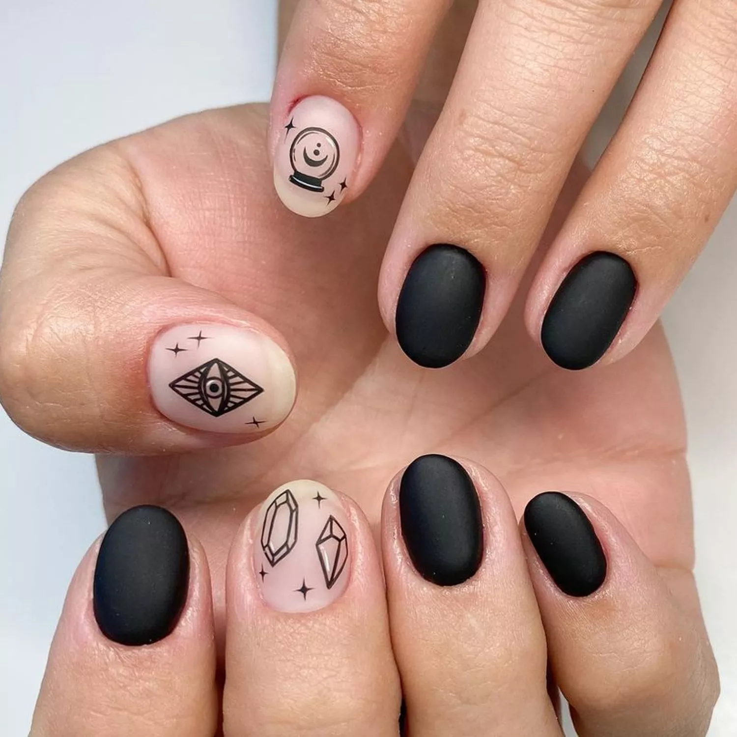 black matte nails with magic ball and evil eye designs