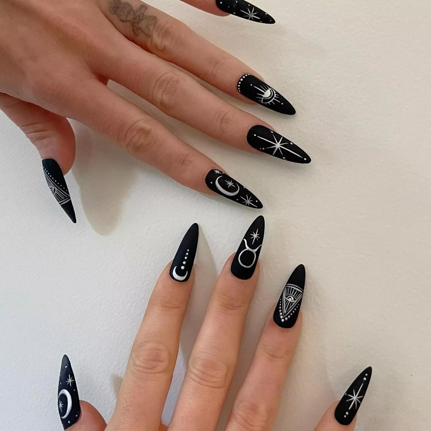 black stiletto nails with astrology design