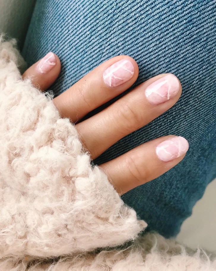 blush pink short manicured nails in a marble inspired design