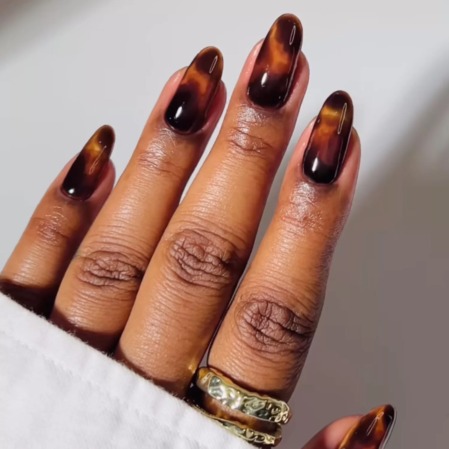 Tortoise shell manicure against a white backdrop 