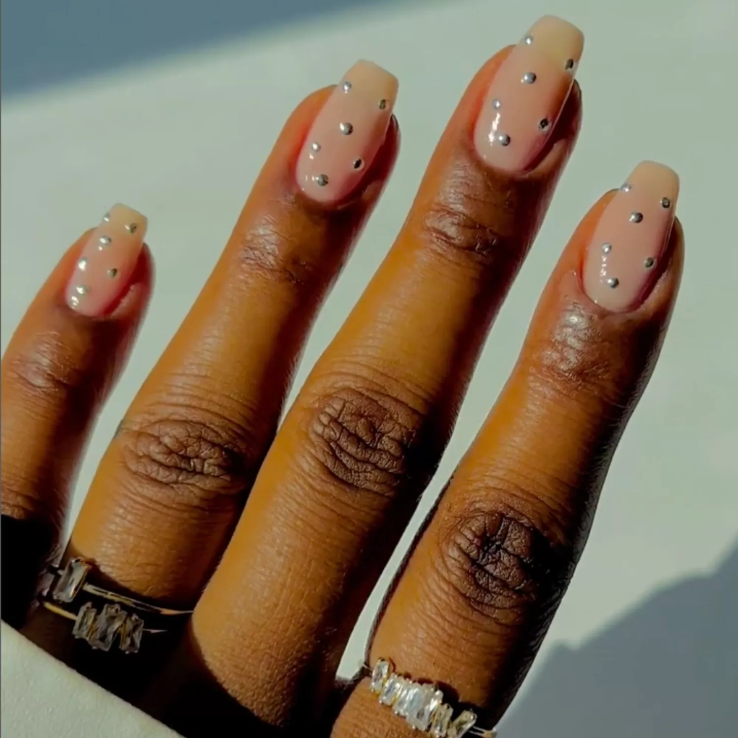 Nude manicure with little silver dot embellishments.