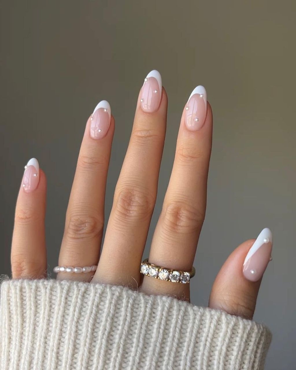 bride displaying her simple and classy pearl dotted white french tip wedding nails