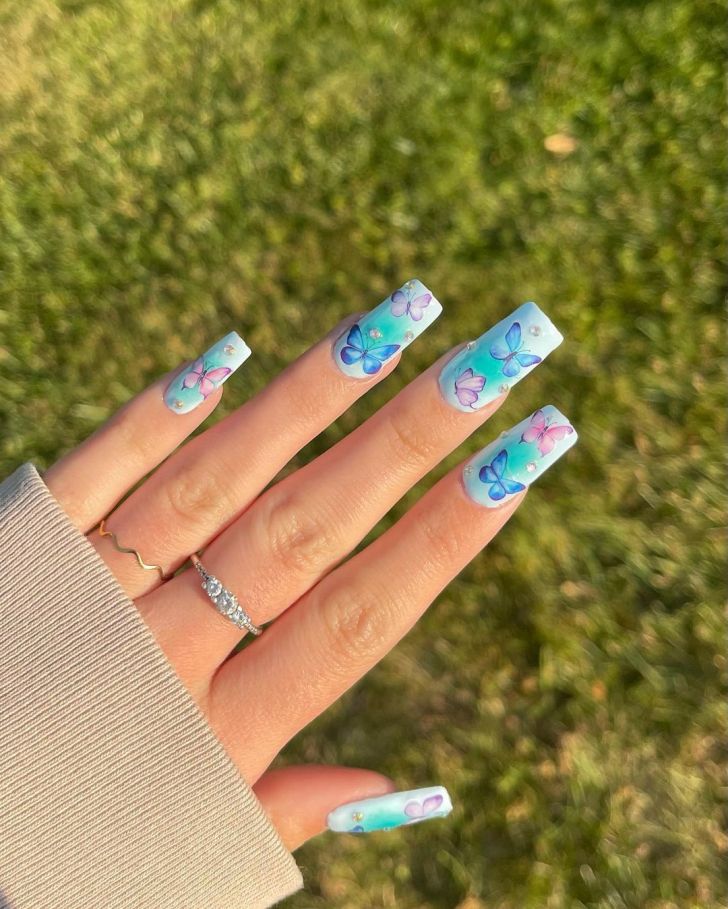 blue coffin shaped Taylor Swift nails with an ombre aura butterfly design inspired by the debut album on the Eras Tour