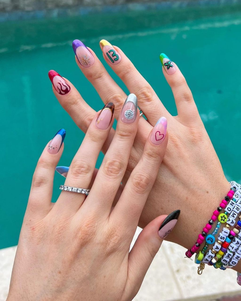 mismatched Taylor Swift nails with cute French tip designs and nail art inspired by each album on the Eras Tour including everything from the number 13 to a heart to a disco ball and more
