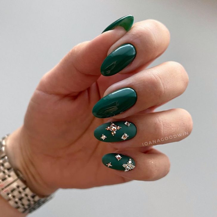 emerald green new years nails with glamorous rhinestone designs on two fingers