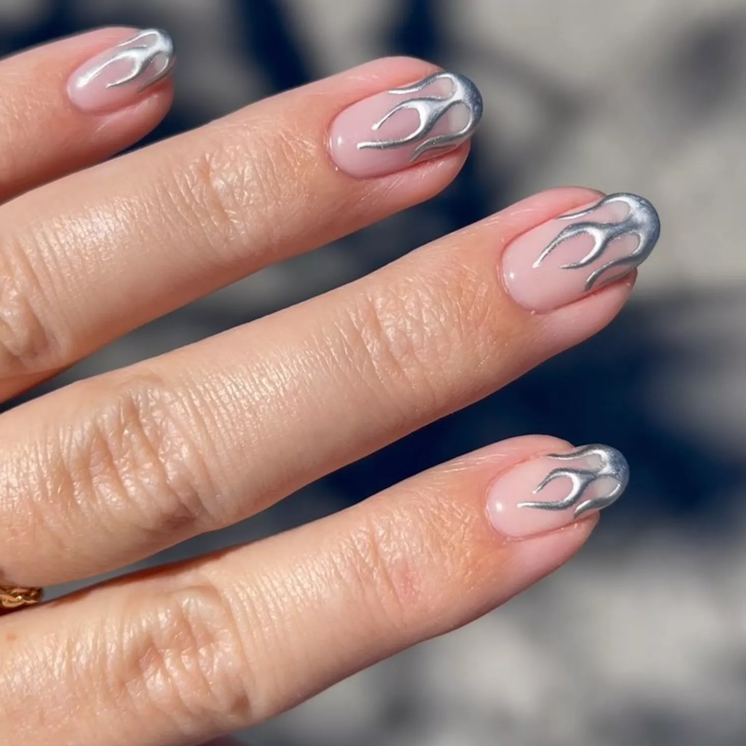 a manicure with silver chrome flames at the tips