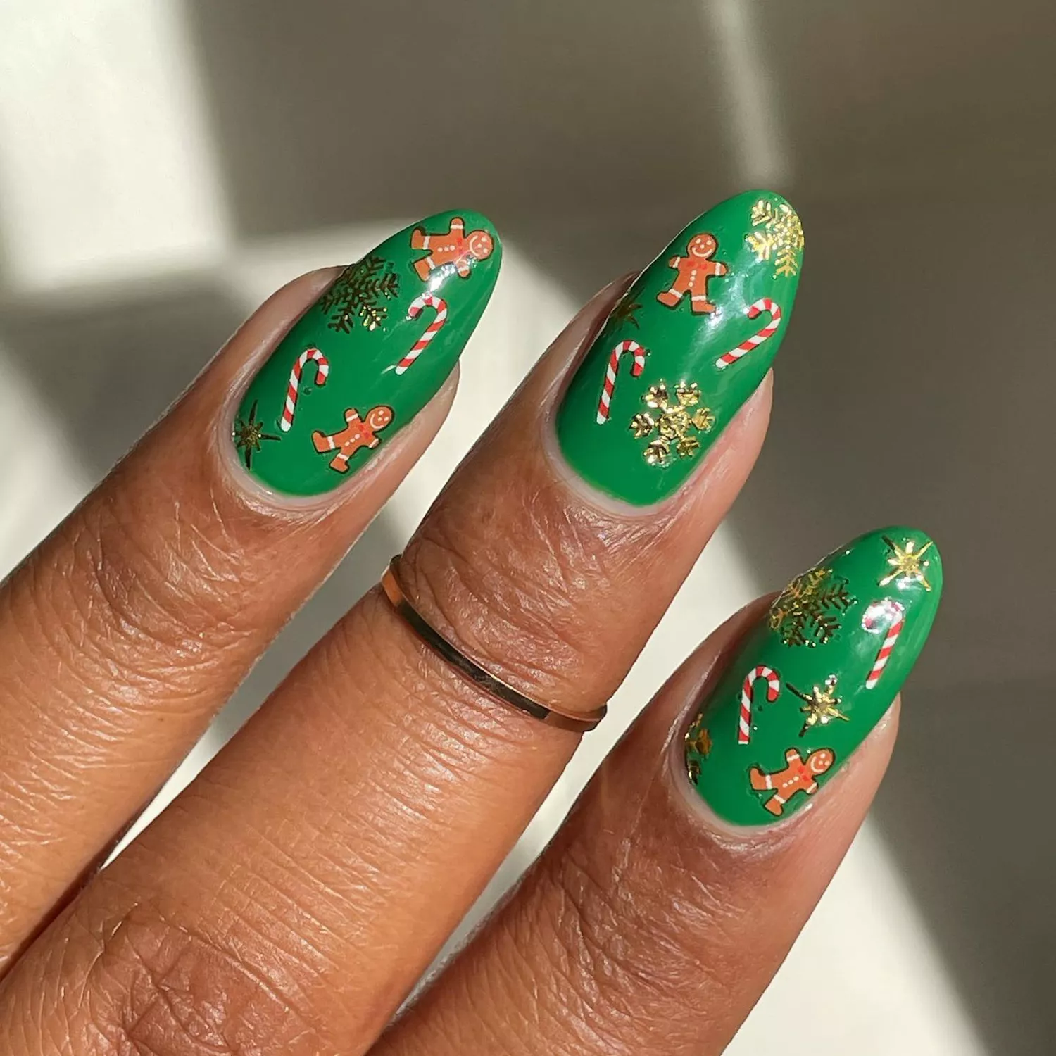 Close up of a green manicure with festive seasonal decals